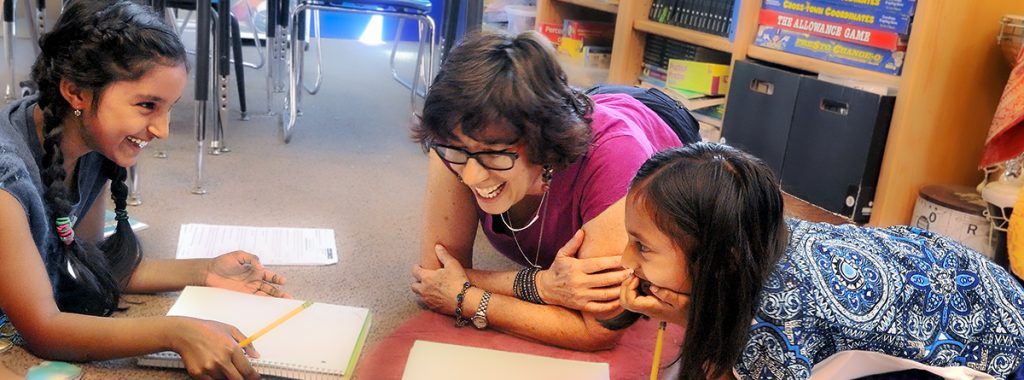 Two girls in 3rd grade work on math together with teacher Ruth Silver at Living Wisdom School of Palo Alto.