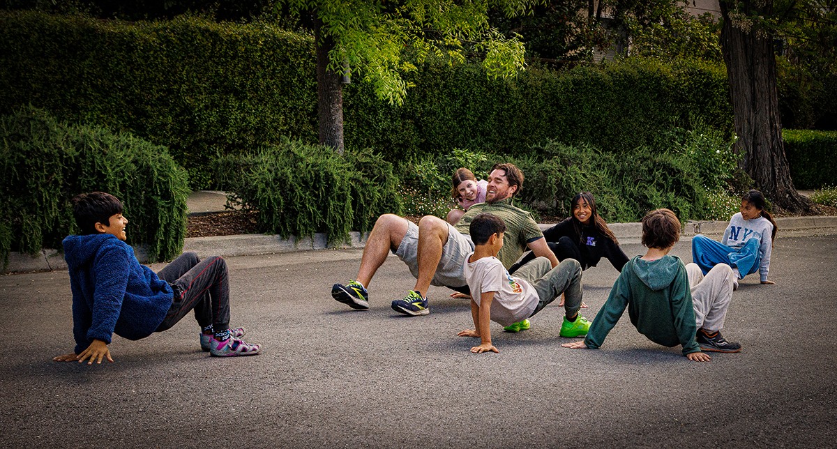 4th & 5th grade teacher Craig Kellogg leads his students in back frog exercises before math class.