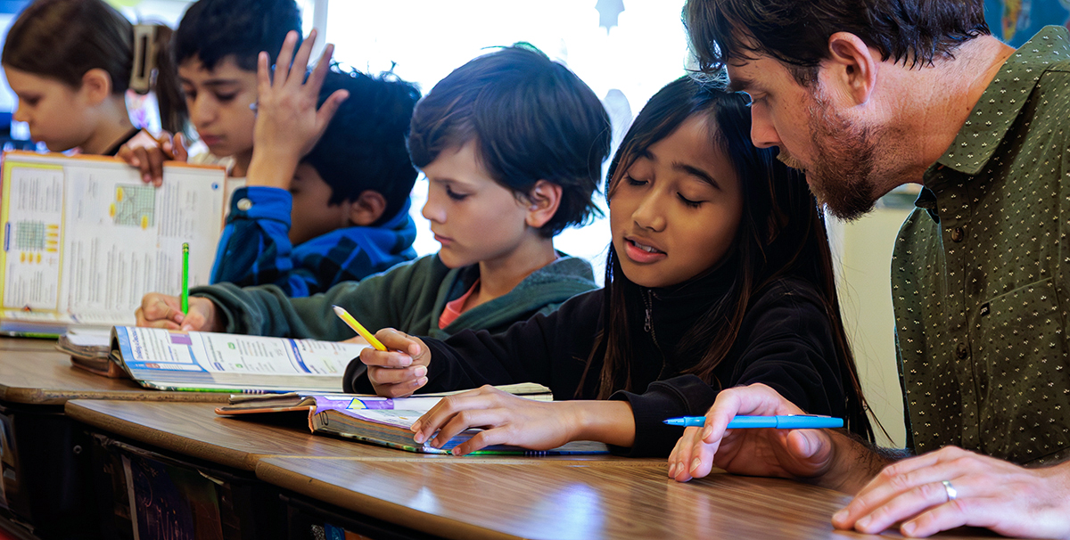 4th & 5th grade teacher Craig Kellogg helps a student with her math at Living Wisdom School of Palo Alto, California