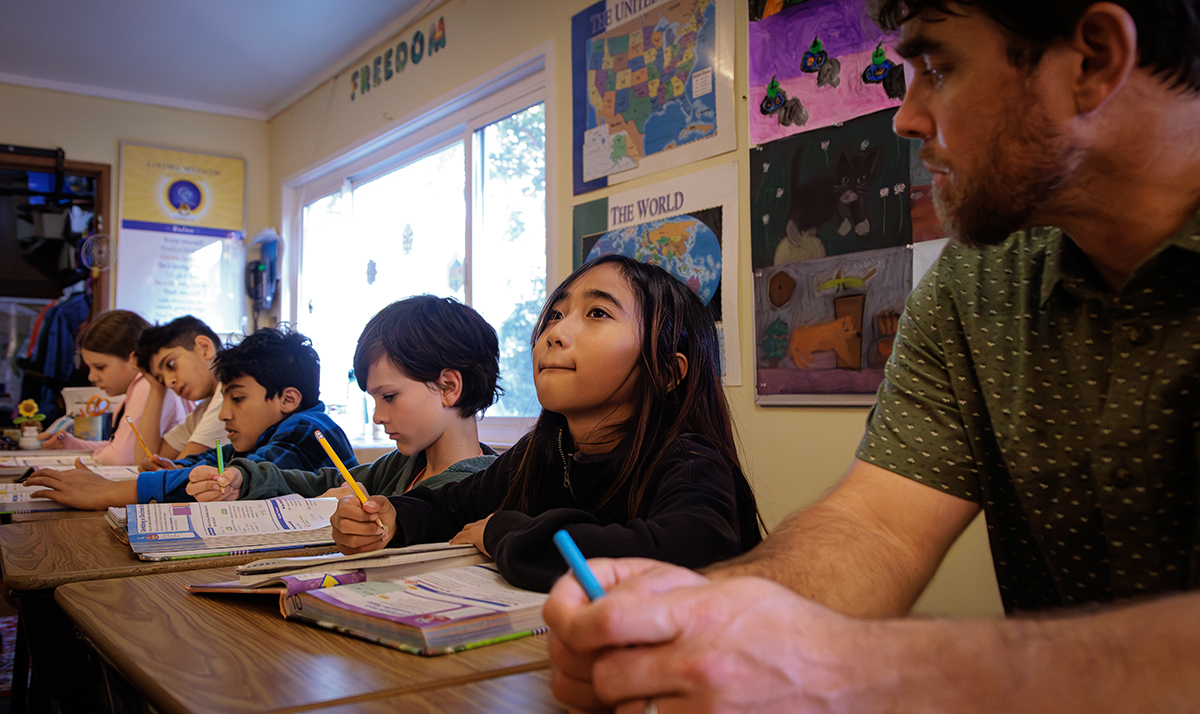 Girl looks up thoughtfully during math class in teacher Craig Kellog's 4th & 5th grade class at Living Wisdom School of Palo Alto, California.