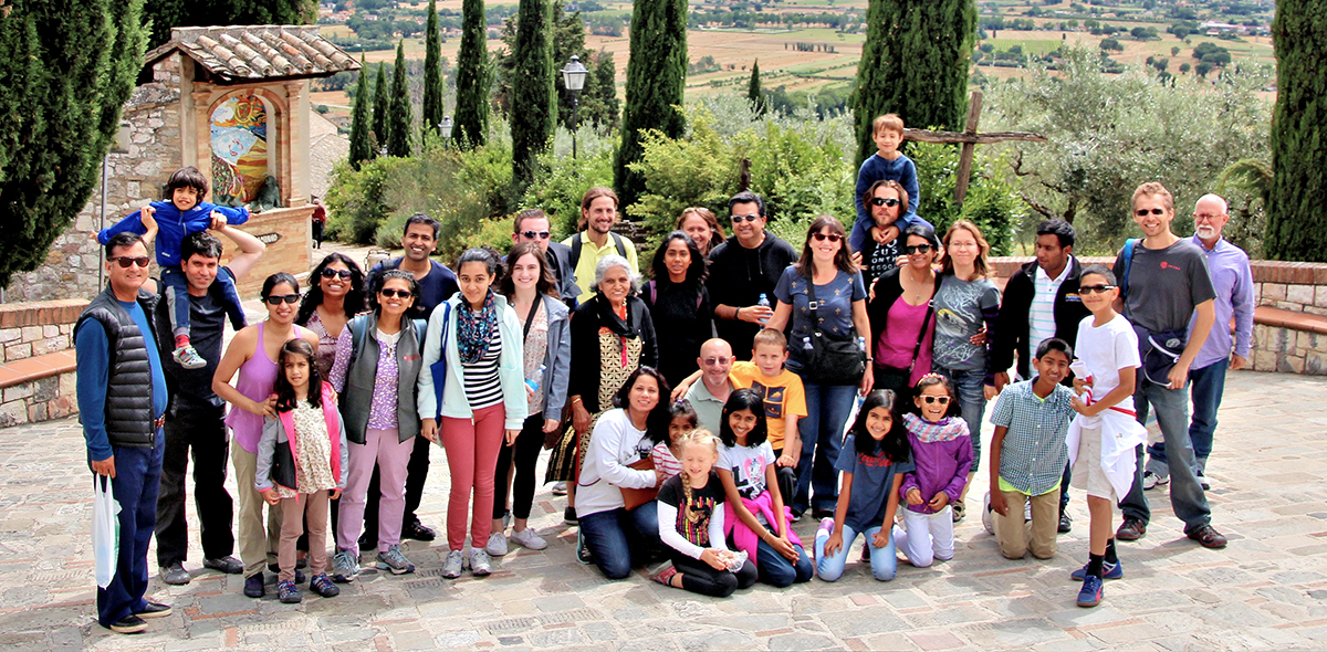Group photo of several dozen adults and children at Assisi, Italy for an Education for Life conference.