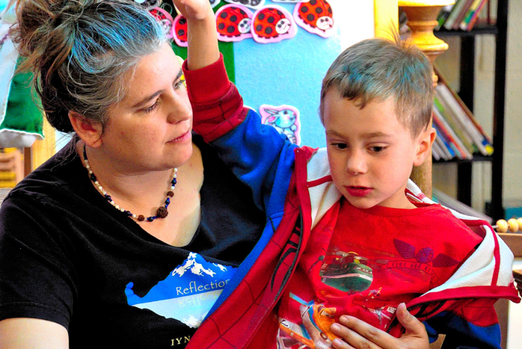 Kindergarten teacher Mahita holds a five-year-old student on her lap.